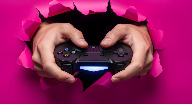 Hands Holding Black Gamepad Controller Breaking Through Bright Pink Torn Paper Background for Gaming and E-sports Concept