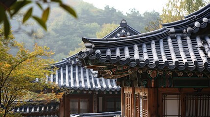 Obraz premium Ancient Korean Hanok Rooftops Framed by Autumn Foliage and Quiet Mountains