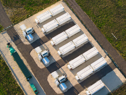 Aerial view of Tiln Photovoltaic Solar Farm and Battery Energy Storage System with rows of white storage units on a gravel base in Retford, England, United Kingdom.