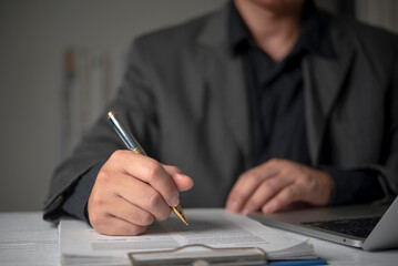 Manager signing legal document clipboard office desk pen typing laptop corporate workflow official...