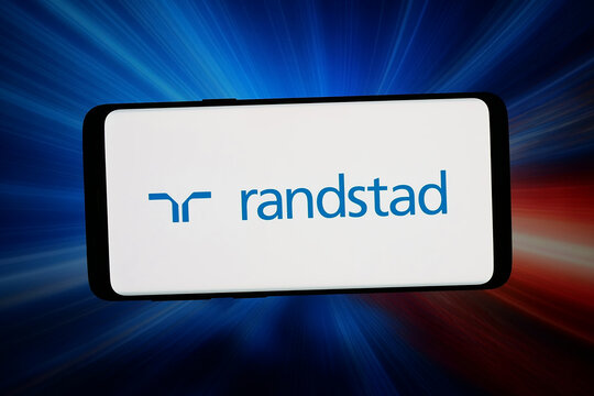 Stuttgart, Germany - 04-13-2026: In this photo illustration, the logo of Dutch human resources company Randstad N.V. is displayed on a smartphone in front of abstract background on computer screen.