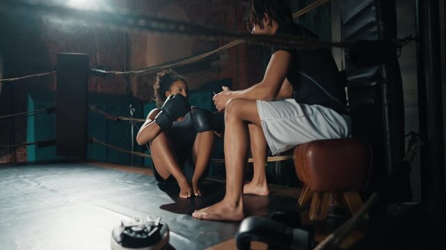 Young athletes chatting cheerfully after workout in gym, black lady and guy. Sport activity and healthy lifestyle of modern people, african ethnicity, positive emotions and good mood, be yourself