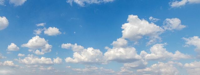 Bright blue daytime sky with fluffy white cumulus clouds — sunny summer day, perfect background for design © Iryna