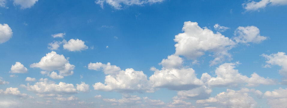 Bright blue daytime sky with fluffy white cumulus clouds &mdash; sunny summer day, perfect background for design