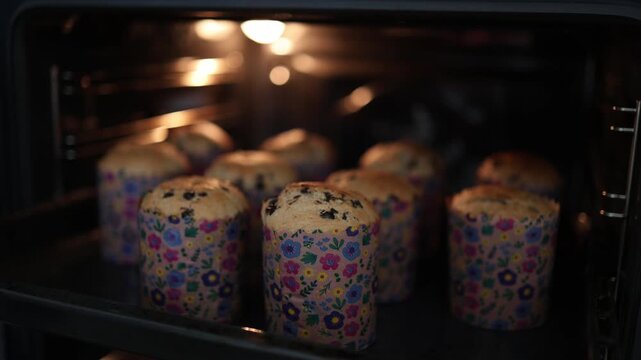 Rows of easter cakes baking on tray in open oven warm light rising dough creating festive homemade baking scene