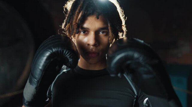 Self-defense and sport workout in fitness club, young african man fighting. Portrait of professional motivated sportsman practicing box and kickboxing, healthy lifestyle and combat sport for keep fit,