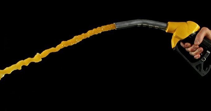 Super slow motion (1000 fps) fuel drops dripping from gasoline nozzle, symbol of depletion and fuel shortage. Minimal liquid flow on black background, dramatic lighting, energy crisis concept.