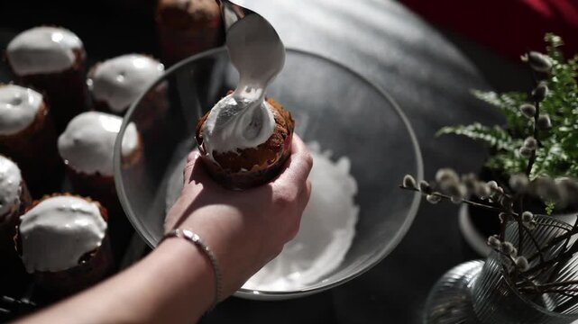 macro shot applying thick white icing on easter bread smooth glossy surface festive dessert preparation traditional homemade paska baking detail