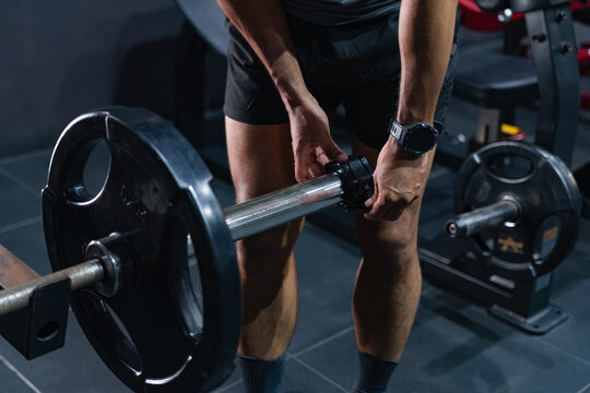 Athlete Preparing for a Barbell Deadlift in a Modern Gym, Man Getting Ready for Deadlift During Strength Training Session.