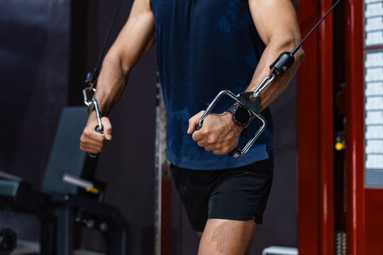 Athletic Male Exercising with Cable Station During Chest Training, strength development and upper body exercise in Gym. Athlete Performing Controlled Cable Fly Motion During upper body training.