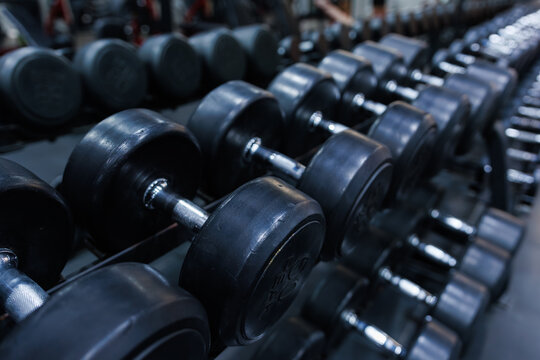 Fitness Center Close Up with Dumbbells and Training Equipment. Modern Workout Facility with Dumbbell Rack.