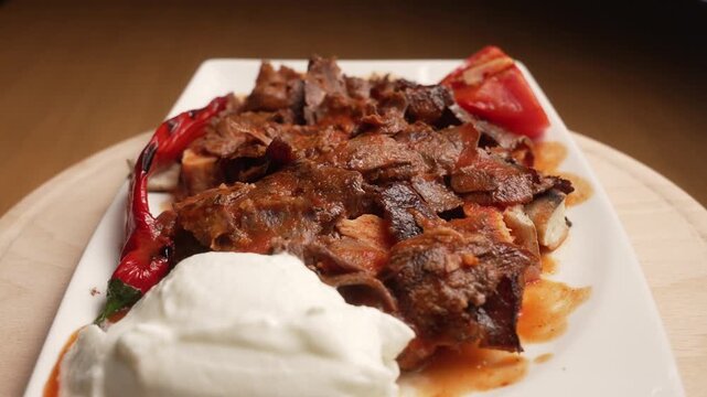 Delicious traditional Turkish Iskender Kebab rotating, served with tomato, yogurt, and grilled pepper, fa01