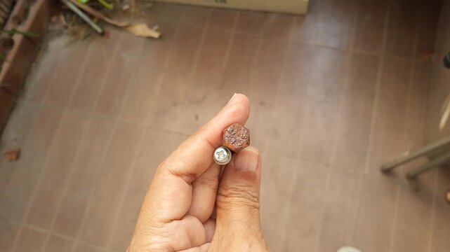 Manufacturing and Industry, Hand Holding Dirty Rustic Screw or Bolt Use for Hold Objects Together and To Position Objects. 