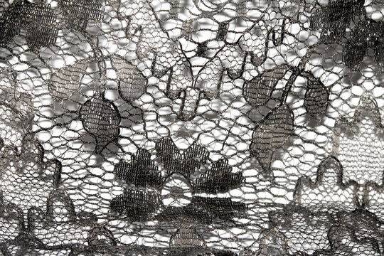 Close up of vintage black gothic lace fabric white on black background embroidery
