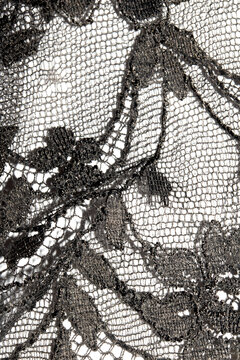 Close up of vintage black gothic lace fabric white on black background embroidery