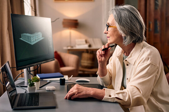 Creative remote work. A mature professional woman is focused on working on an architectural project at home. Work and study from home.