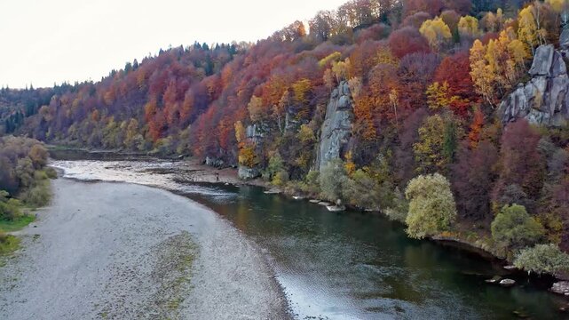 Shallow mountain river at foothill with terracotta forests