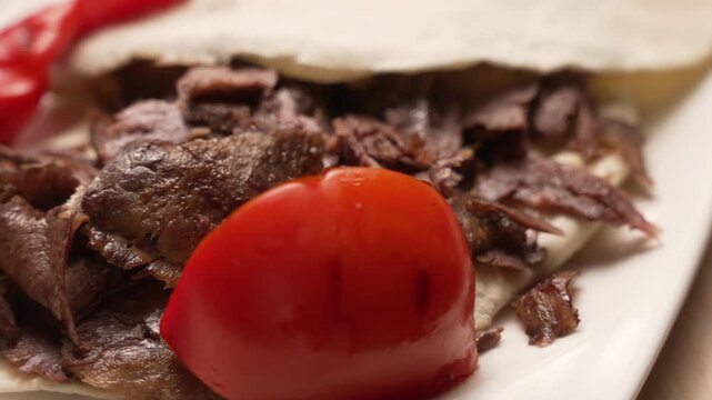 Traditional Turkish Doner Kebab served on a plate with pita bread, tomato, and roasted pepper, fa01