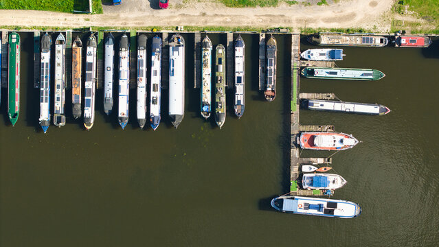 Aerial view of narrowboats and leisure craft moored at the marina docks on a sunny day with calm water Rawcliffe Bridge, England, United Kingdom.