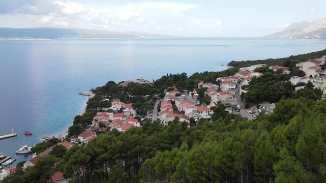 Brela, Croatia. Coastal village, sea and mountains. Houses, villas, hotels with red roofs. Drone view. Croatian Adriatic Sea, Makarska Riviera