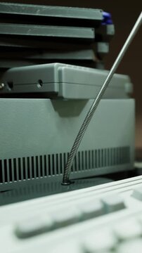 A workspace shows several computers stacked on top of each other. A keyboard is positioned close by. The setting appears to be well lit and organized.