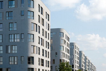 Fototapeta premium Row of modern apartment buildings with curved facades, blue sky