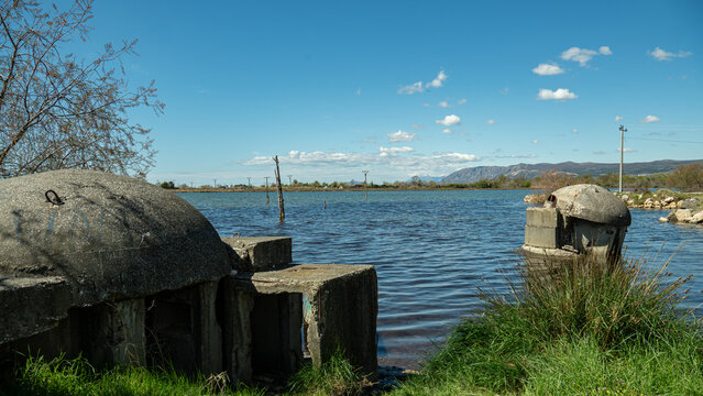 A weathered communist-era concrete bunker stands abandoned in a grassy field in Ishull Lezh&euml;, Albania, symbolizing the country's unique military history.