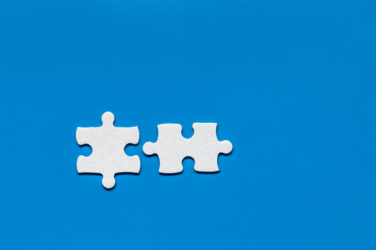 White jigsaw puzzle. White puzzle pieces on color background. Unfinished white jigsaw puzzle pieces on color background.