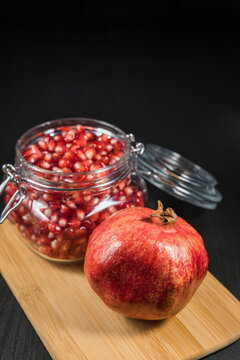 Ripe pomegranate fruit in a jar on wooden vintage background