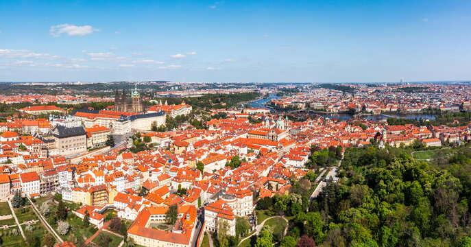 Panoramic view of Prague featuring historic buildings and vibrant rooftops on a sunny day in summer. View of Prague, Czech Republic, showcasing the city's iconic architecture and red-tiled roofs.