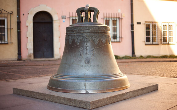 The Wishing Bell in Warsaw Old Town: Historic Bronze Bell on Kanonia Street, Polish Landmark and Cultural Heritage Monument with Ornate Reliefs under Soft Daylight