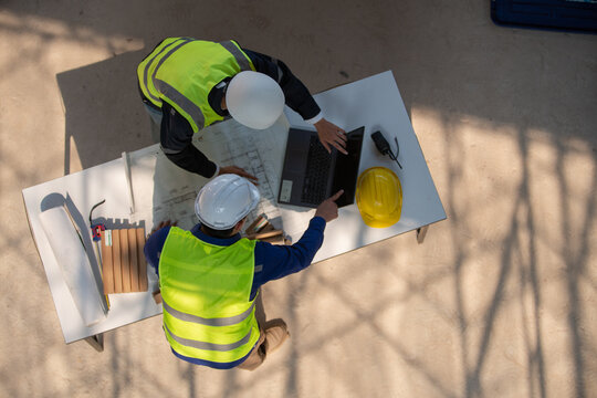 Construction workers collaborating on project planning job site work environment aerial view teamwork and efficiency