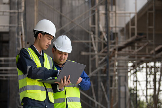 Construction workers collaborate on project plans at a building site industry action urban environment professional viewpoint
