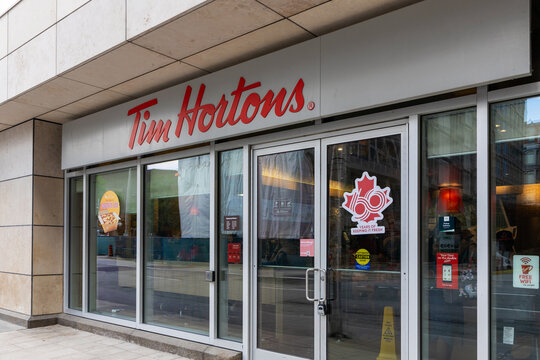 Ottawa, Canada - July 1, 2025: Tim Hortons logo, coffee shop storefront