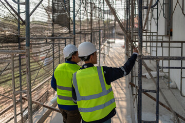 Construction workers inspecting scaffolding installation construction site image urban environment close-up view safety compliance © EmmaStock