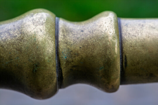 Macrophotographie d'un tuyau en laiton vintage avec patine naturelle.