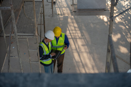 Construction site collaboration between engineers urban environment professional meeting industrial setting close-up view productivity focus