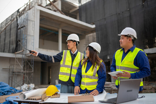 Construction team collaborating on project plans at urban building site professional environment overhead view teamwork concept