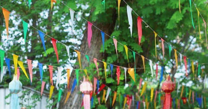 Colorful pennant flags hanging outdoors, gently swaying to create a festive, cheerful atmosphere. Perfect for celebrations, parties, and outdoor events