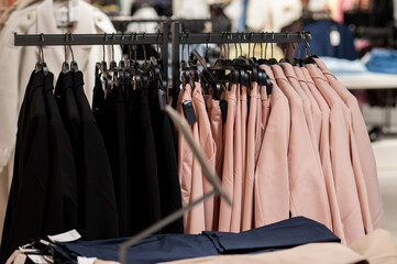 Naklejka premium Row of Black and Pink Women's Blazers on Hangers in Fashion Retail Store Clothing Rack Display