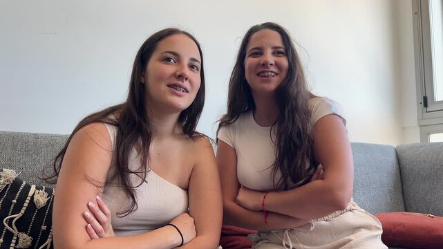 Medio plano de dos chicas con brackets en el sof&aacute;