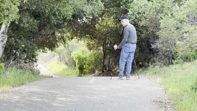 Senior man with hiking poles checks his surroundings