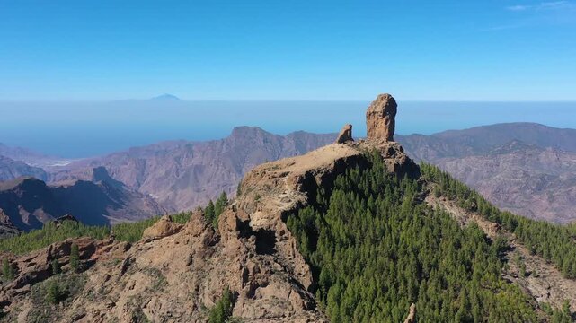 Roque Nublo and Pico de Teide in the background on Gran Canaria Island, Spain. Panoramic view of Roque Nublo sacred mountain, Roque Nublo Rural Park, Gran Canary, Canary Islands, Spain.