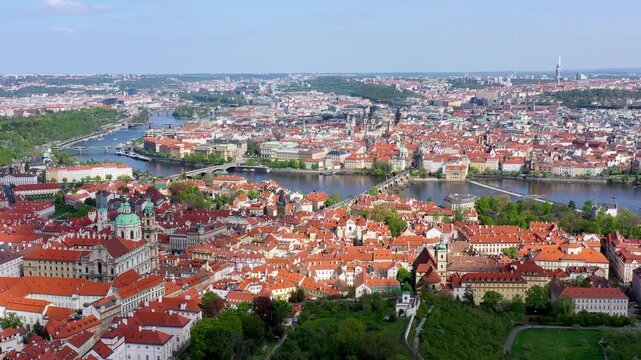 View of Prague featuring vibrant rooftops on a sunny day in summer. Aerial view of Prague, Charles Bridge over Vltava river in Prague, Czechia. Old Town of Prague, Czech Republic.
