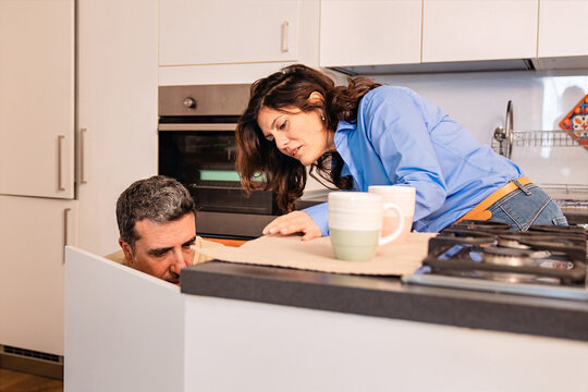 Couple Inspecting Kitchen Appliance Problem at Home. Couple Inspecting Kitchen Appliance Problem at Home