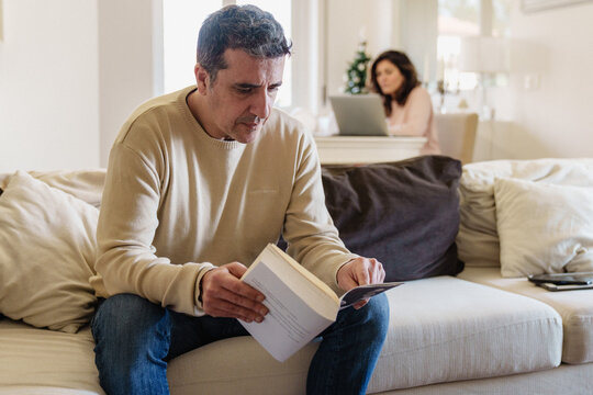 Couple Sharing Living Room Space with Distinct Activities. Couple at Home Engaged in Separate Activities in Shared Living Space
