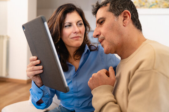 Couple using a tablet together at home, sharing digital content in a relaxed everyday moment.