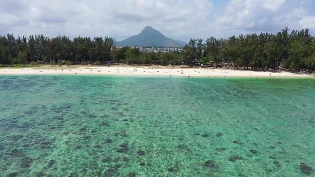 Aerial Landscape view of Flic en Flac beach with cityscape of Flic en Flac town and Mauritius mountain landscape in the background. Best tropical beaches in Flic en Flac, Mauritius island.