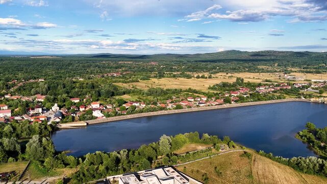 Scenic view of Tismana village in Gorj County Romania under a bright blue sky with fluffy clouds. A stunning landscape captures the beauty of Tismana village in Gorj County. Tismana, Romania.
