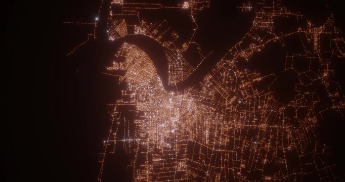 Paramaribo (Suriname) aerial view at night. Top view on modern city with street lights. Camera is zooming out, rotating counterclockwise. Vertical video. The north is on the left side